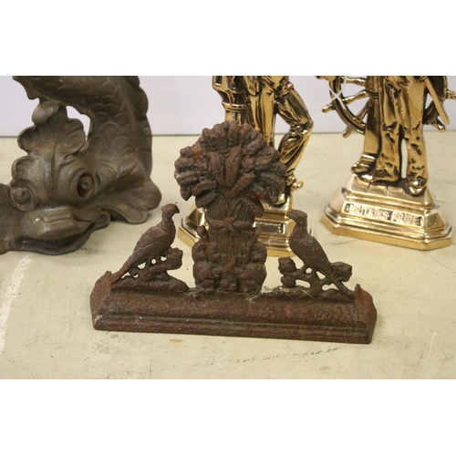445 - Four cast iron and brass door stops to include 2 x brass Britains Pride examples, cast iron Chinese ... 
