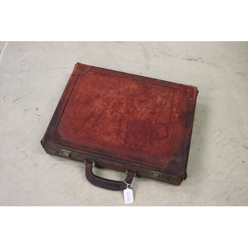 454 - Three leather bags to include two brief cases and a satchel.