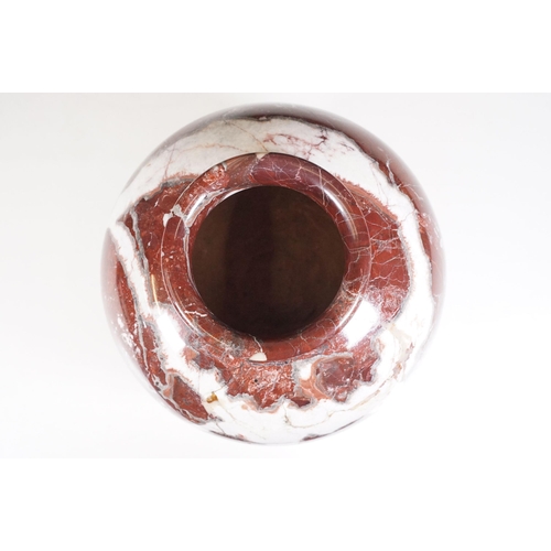 139 - Polished marble vase of spherical footed form, with tones of red and off-white, moulded rim and doub... 