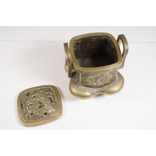 141 - Chinese bronzed lidded censer with dragon and traditional detailing, with twin handles on four legs,... 