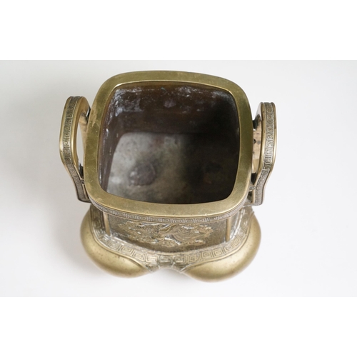 141 - Chinese bronzed lidded censer with dragon and traditional detailing, with twin handles on four legs,... 