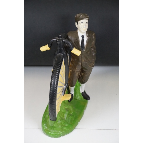 146 - Cast plaster figurine in the form of a gentleman with a penny farthing, hand painted. Measures 35cm ... 
