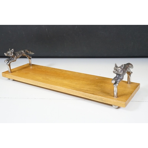 152 - Wooden bookstand with cast metal supports in the form of running foxes, on four ball feet, 44cm long