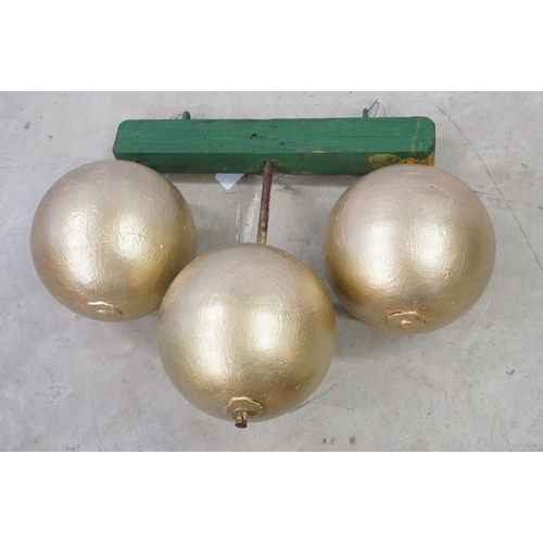 466 - 1950s pawn brokers painted glass golden balls on wooden hanger, together with a painted District Lin... 