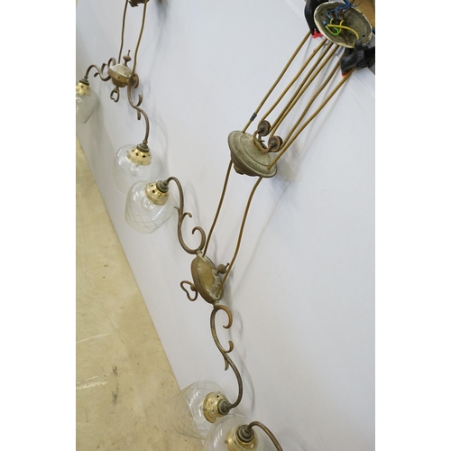 469 - Three early 20th Century rise and fall hall lights, each having two scrolled arms with cut glass sco... 