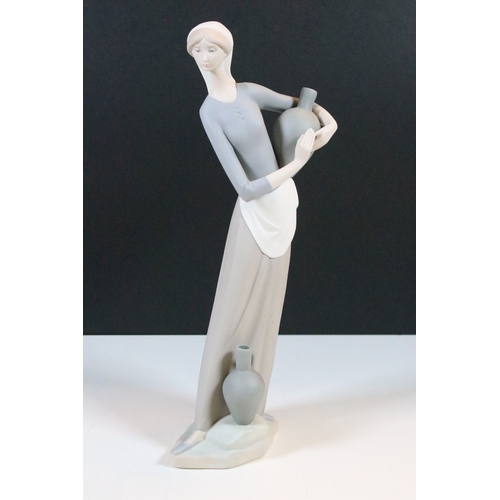 27 - Lladro Nao 'Girl carrying water jar' bisque finish figurine, H 32cm together with Lladro 'Girl at th... 