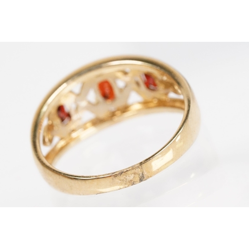 147 - 9ct gold and garnet three stone ring being set with three oval cut garnets in a pierced mount settin... 