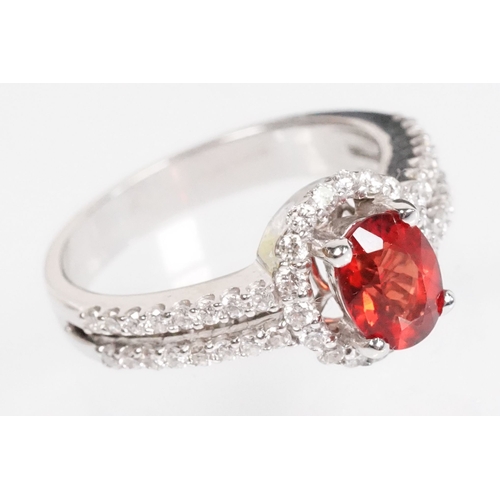 149 - 18ct gold red Andesine feldspar and diamond dress ring. The ring being set with an oval red a Andesi... 