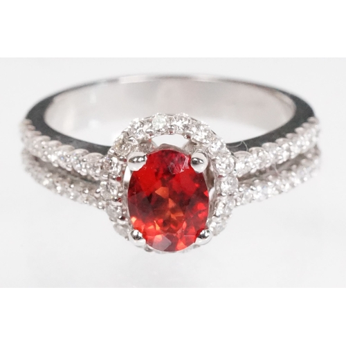 149 - 18ct gold red Andesine feldspar and diamond dress ring. The ring being set with an oval red a Andesi... 