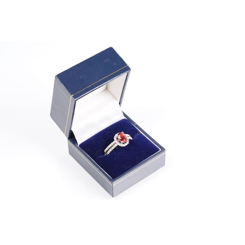 149 - 18ct gold red Andesine feldspar and diamond dress ring. The ring being set with an oval red a Andesi... 