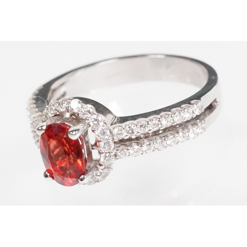 149 - 18ct gold red Andesine feldspar and diamond dress ring. The ring being set with an oval red a Andesi... 