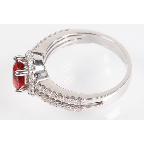 149 - 18ct gold red Andesine feldspar and diamond dress ring. The ring being set with an oval red a Andesi... 