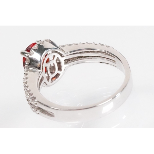149 - 18ct gold red Andesine feldspar and diamond dress ring. The ring being set with an oval red a Andesi... 