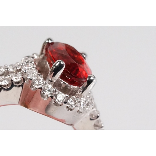 149 - 18ct gold red Andesine feldspar and diamond dress ring. The ring being set with an oval red a Andesi... 