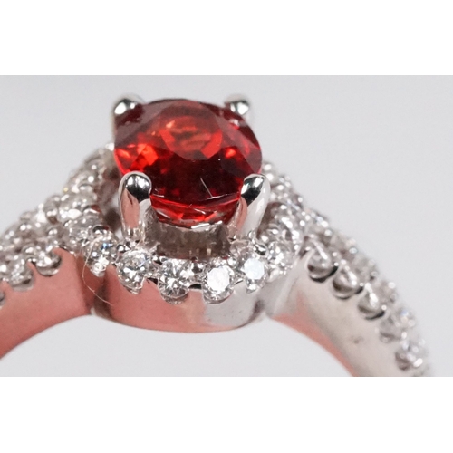 149 - 18ct gold red Andesine feldspar and diamond dress ring. The ring being set with an oval red a Andesi... 