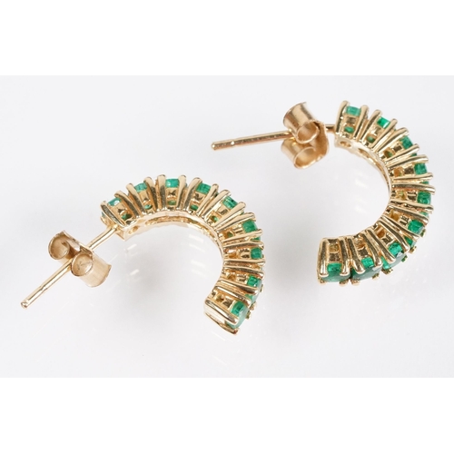 153 - Pair of 14ct gold and emerald half hoop earrings being set with nine round cut emeralds. Marked 14k.... 