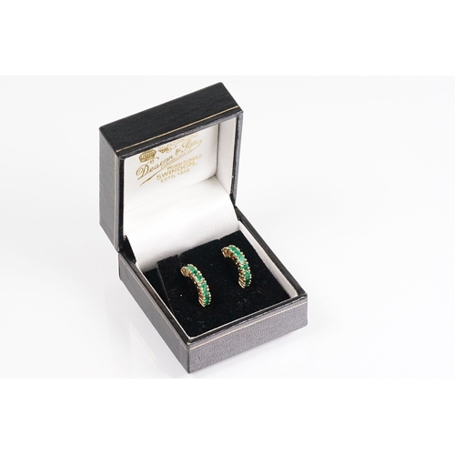 153 - Pair of 14ct gold and emerald half hoop earrings being set with nine round cut emeralds. Marked 14k.... 