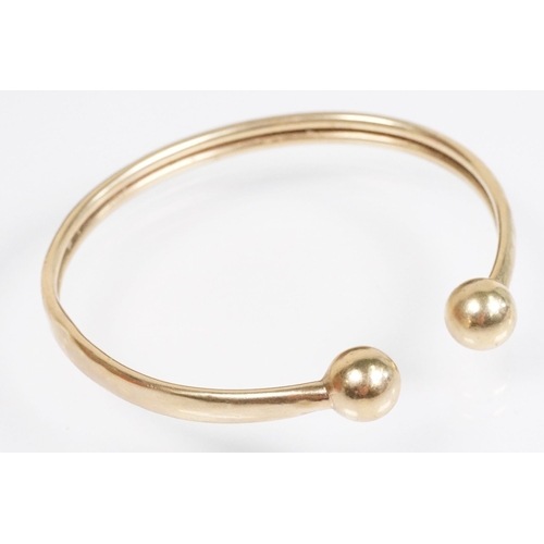 156 - 9ct gold bangle bracelet having ball terminals. Hallmarked Birmingham. Measures 2.5 inches.