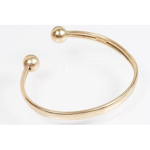 156 - 9ct gold bangle bracelet having ball terminals. Hallmarked Birmingham. Measures 2.5 inches.