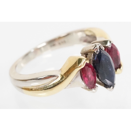 172 - 18ct gold, ruby and sapphire three stone ring. The ring being set with a marquise cut sapphire to ce... 