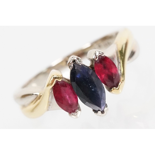 172 - 18ct gold, ruby and sapphire three stone ring. The ring being set with a marquise cut sapphire to ce... 