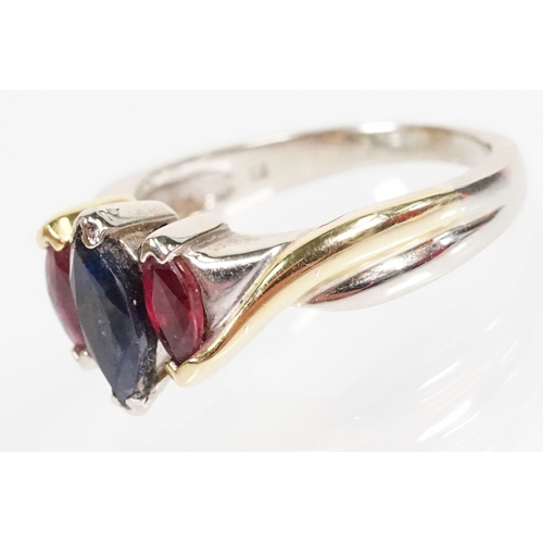 172 - 18ct gold, ruby and sapphire three stone ring. The ring being set with a marquise cut sapphire to ce... 