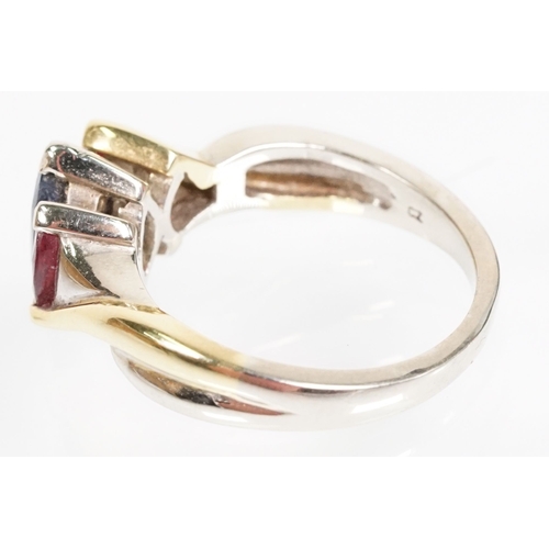 172 - 18ct gold, ruby and sapphire three stone ring. The ring being set with a marquise cut sapphire to ce... 