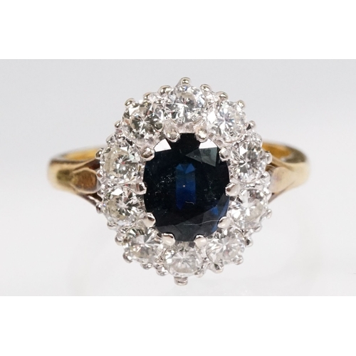 7 - 18ct gold sapphire and diamond halo ring. The ring being set with an oval mixed cut blue sapphire wi... 