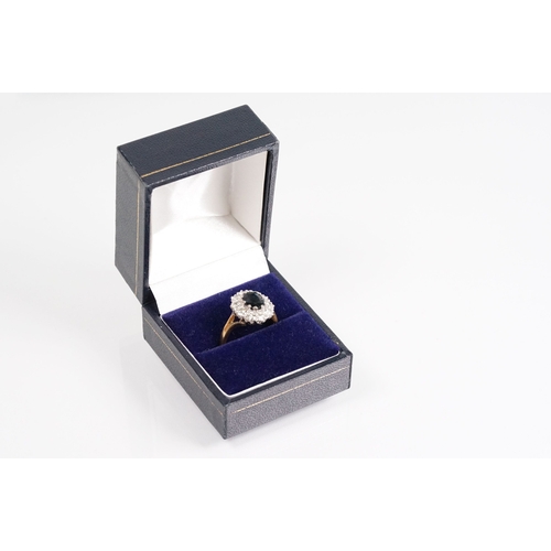 7 - 18ct gold sapphire and diamond halo ring. The ring being set with an oval mixed cut blue sapphire wi... 