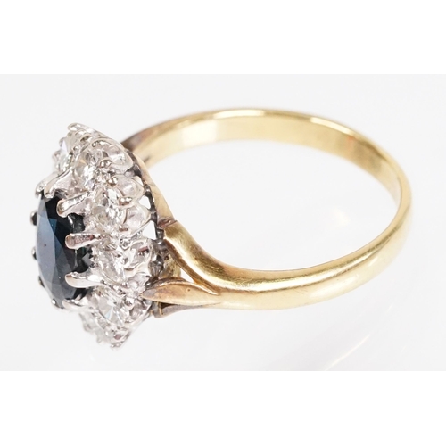 7 - 18ct gold sapphire and diamond halo ring. The ring being set with an oval mixed cut blue sapphire wi... 