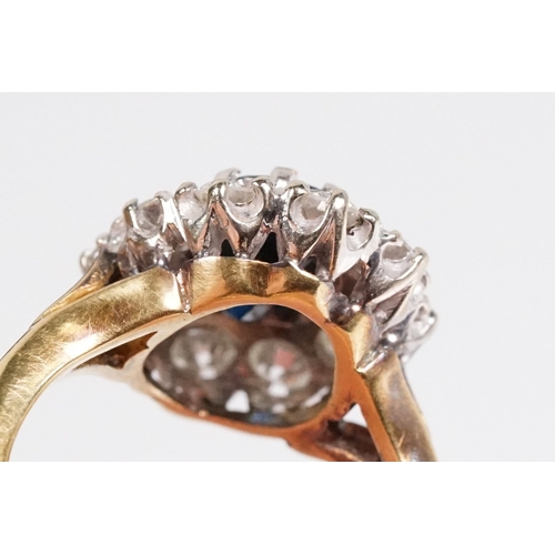 7 - 18ct gold sapphire and diamond halo ring. The ring being set with an oval mixed cut blue sapphire wi... 