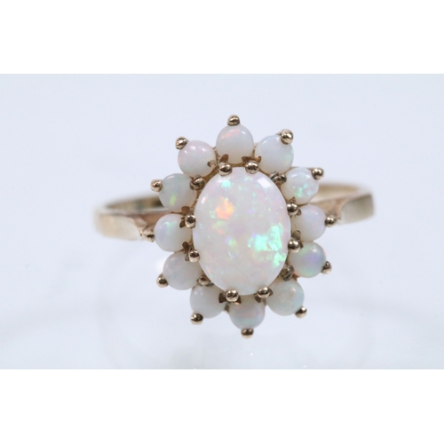 46 - 9ct gold and opal cluster ring. The ring being set with an oval opal cabochon to centre with a halo ... 