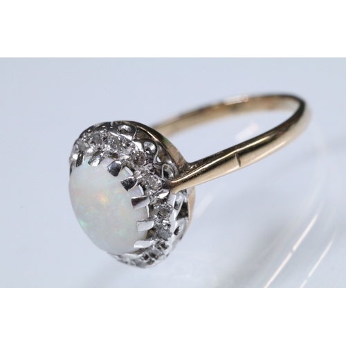 139 - 9ct gold, opal and diamond halo ring. The ring being set with an oval opal cabochon to the centre wi... 