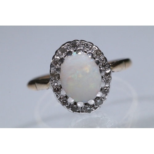 139 - 9ct gold, opal and diamond halo ring. The ring being set with an oval opal cabochon to the centre wi... 