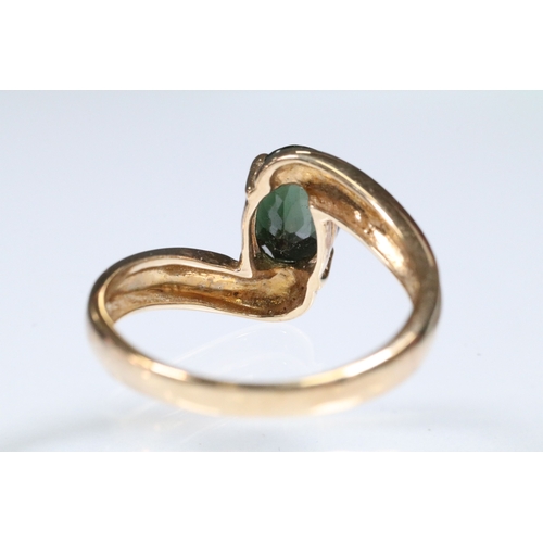 148 - 9ct gold and green tourmaline cross over ring set with an oval cut tourmaline to the centre. Hallmar... 