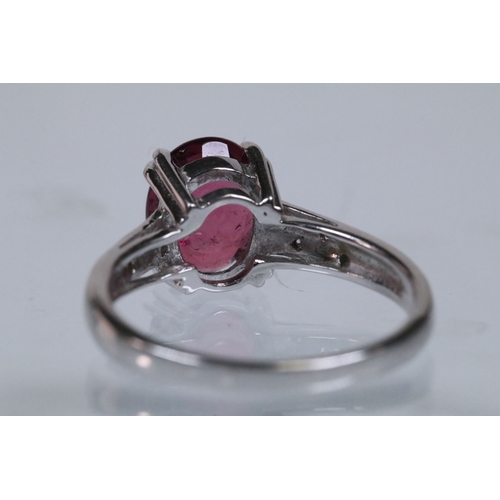 154 - 18ct white gold and rubellite (red tourmaline) and diamond dress ring. The ring being set with an ov... 