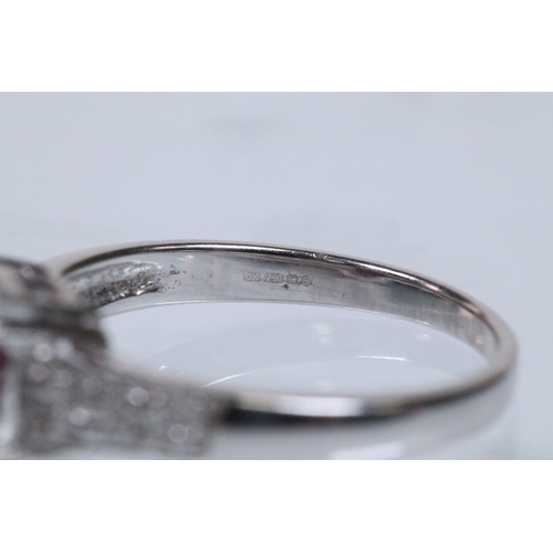 154 - 18ct white gold and rubellite (red tourmaline) and diamond dress ring. The ring being set with an ov... 