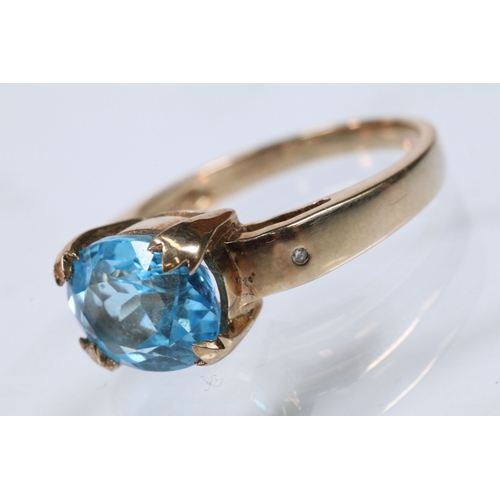 159 - 9ct gold and topaz dress ring set with an oval cut topaz flanked by two diamond accent stones. Hallm... 