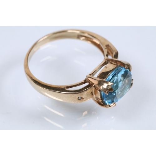 159 - 9ct gold and topaz dress ring set with an oval cut topaz flanked by two diamond accent stones. Hallm... 