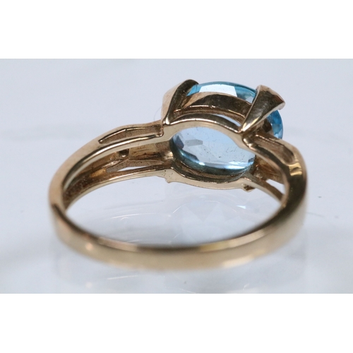 159 - 9ct gold and topaz dress ring set with an oval cut topaz flanked by two diamond accent stones. Hallm... 