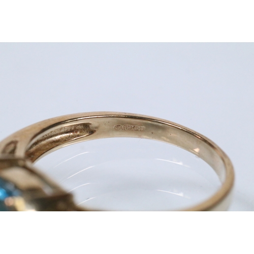159 - 9ct gold and topaz dress ring set with an oval cut topaz flanked by two diamond accent stones. Hallm... 