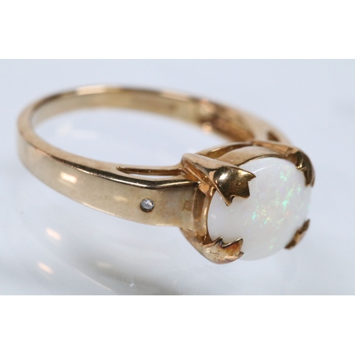 167 - 9ct gold and opal ring set with an oval opal cabochon with two diamond accent stones. Hallmarked Bir... 