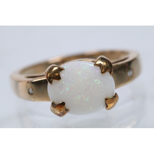 167 - 9ct gold and opal ring set with an oval opal cabochon with two diamond accent stones. Hallmarked Bir... 