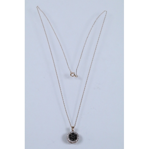 129 - Two 9ct gold pendant necklaces to include a black and white diamond pendant on a fine link chain (pe... 
