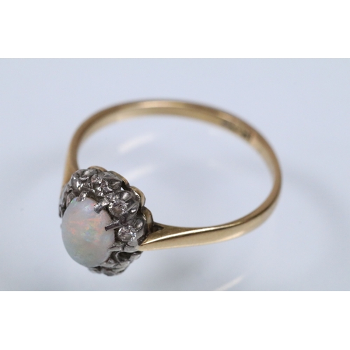 135 - 18ct opal and diamond halo ring having an opal cabochon to the centre with a halo of round cut diamo... 