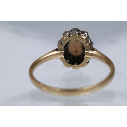 135 - 18ct opal and diamond halo ring having an opal cabochon to the centre with a halo of round cut diamo... 