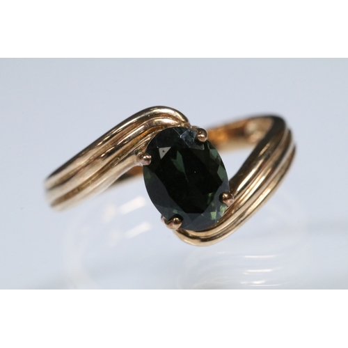 148 - 9ct gold and green tourmaline cross over ring set with an oval cut tourmaline to the centre. Hallmar... 