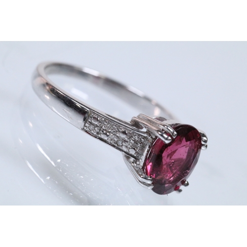154 - 18ct white gold and rubellite (red tourmaline) and diamond dress ring. The ring being set with an ov... 