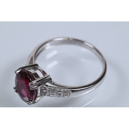 154 - 18ct white gold and rubellite (red tourmaline) and diamond dress ring. The ring being set with an ov... 