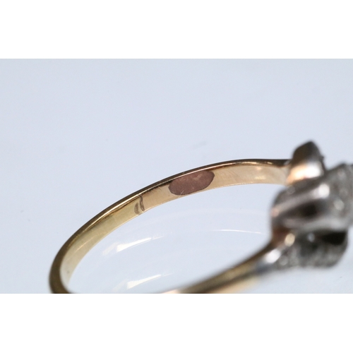 161 - Early 20th Century three stone diamond ring with a cross over setting. Unmarked, tests indicate 18ct... 